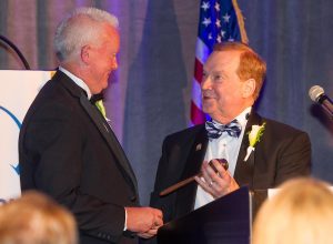 Mike Drews, immediate past president of Illinois REALTORS®, hands the gavel to newly-installed President Doug Carpenter at a ceremony Thursday in Naperville. 