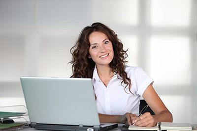 Businesswoman In Front Of Computer In The Office Online Courses are smart solutions