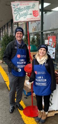 Two REALTORS ring bells by Salvation Army red kettles