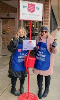 Two members posing with Salvation Army red kettle