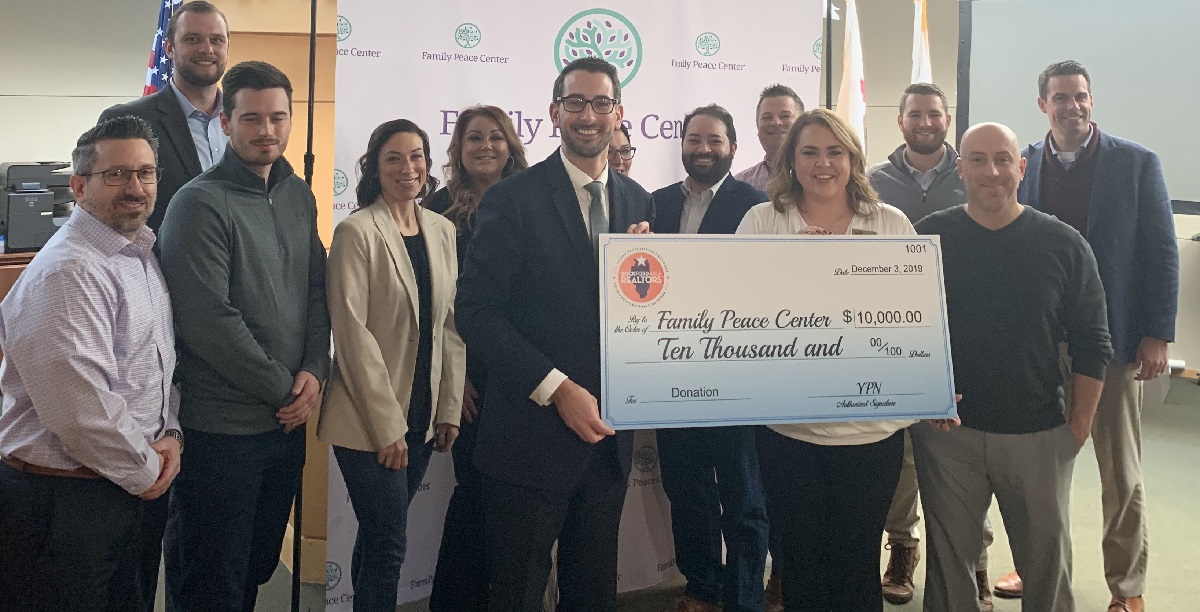 Group photo of Rockford Area REALTORS® presenting check to Rockford Mayor Tom McNamara for the Rockford Family Peace Center.