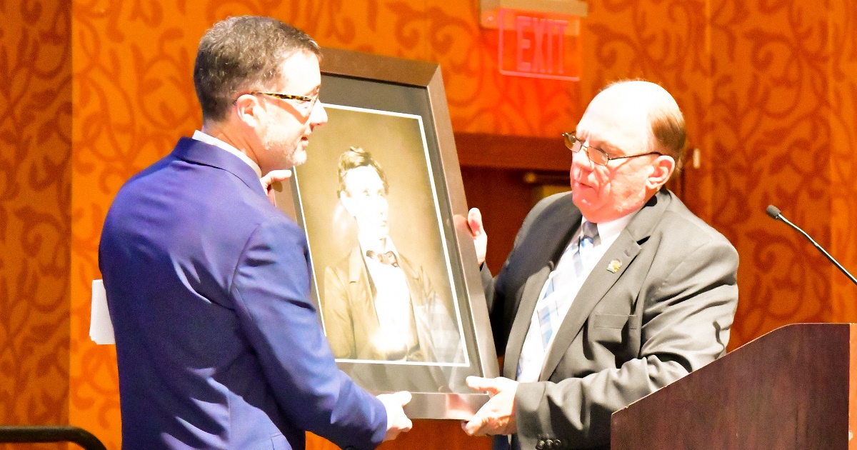 NAR President Vince Malta, an Abraham Lincoln painting and Illinois REALTORS President Ed Neaves.