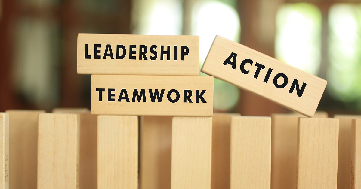 leadership, teamwork and action printed on three separate wooden blocks